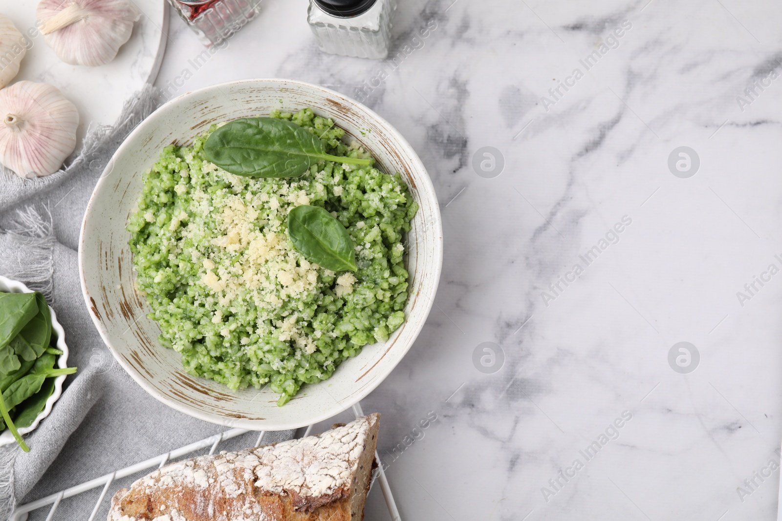 Photo of Tasty spinach risotto served on white marble table, flat lay. Space for text