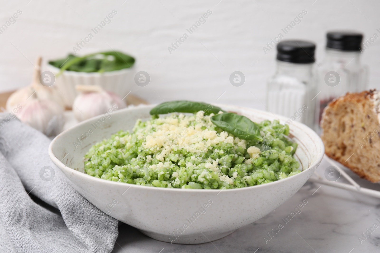 Photo of Tasty spinach risotto served on white marble table, closeup