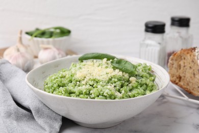 Photo of Tasty spinach risotto served on white marble table, closeup