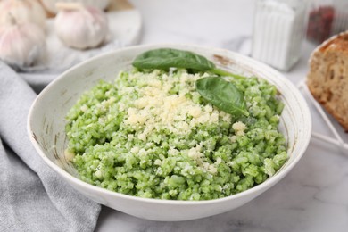 Photo of Tasty spinach risotto served on white marble table, closeup