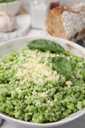 Photo of Tasty spinach risotto served on table, closeup