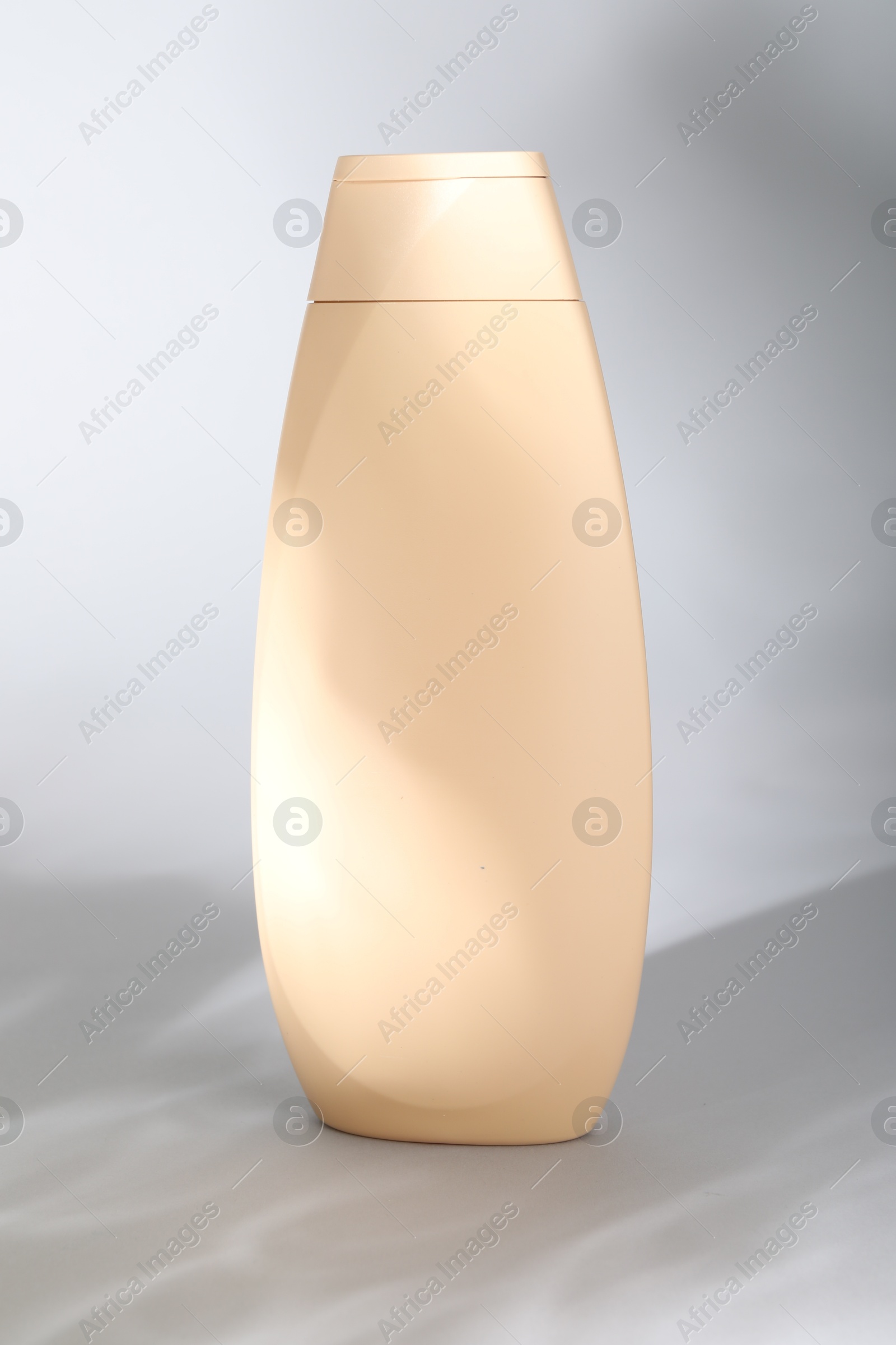 Photo of Shampoo in container on grey background. Personal care product