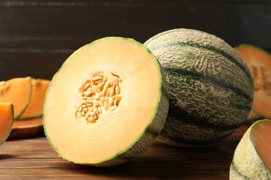 Photo of Cut Cantaloupe melon on wooden table, closeup