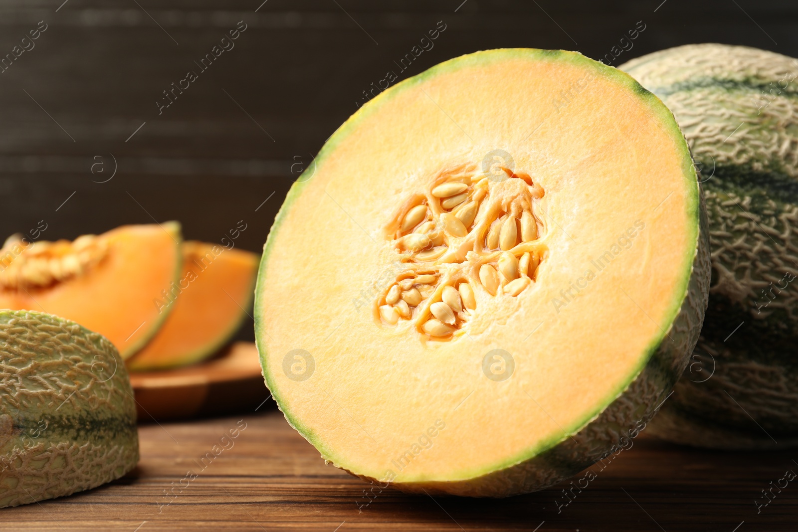 Photo of Cut Cantaloupe melon on wooden table, closeup