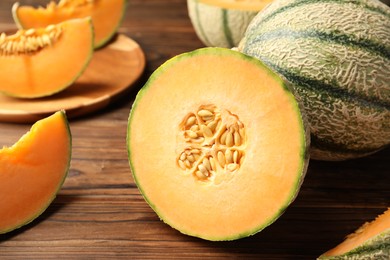 Photo of Cut Cantaloupe melon on wooden table, closeup