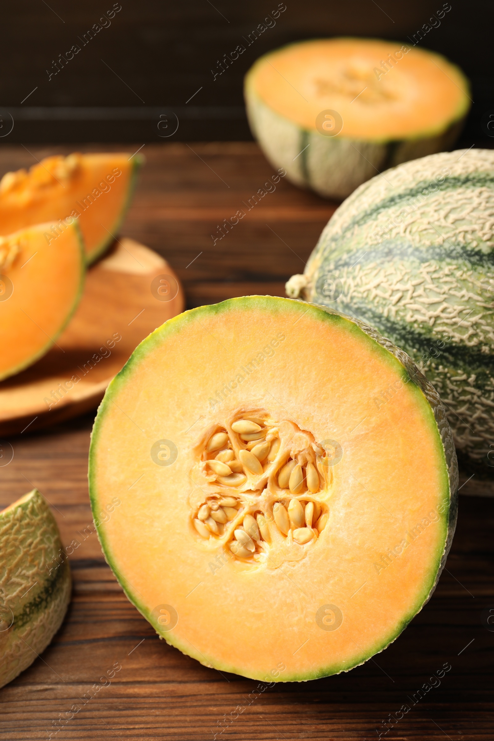 Photo of Cut Cantaloupe melon on wooden table, closeup