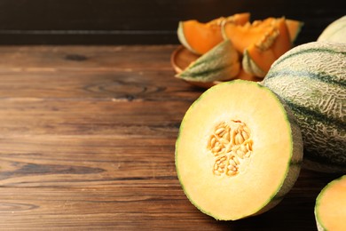 Cut Cantaloupe melon on wooden table, space for text