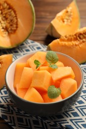 Photo of Pieces of Cantaloupe melon and mint in bowl on table, closeup