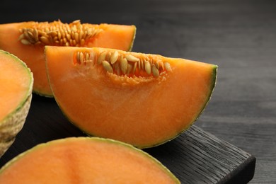 Photo of Fresh ripe Cantaloupe melon on dark wooden table, closeup