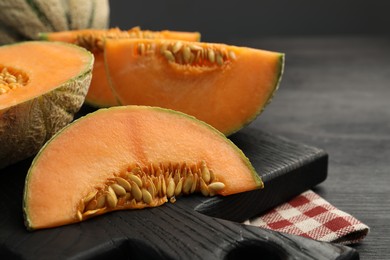 Photo of Fresh ripe Cantaloupe melons on dark wooden table, closeup