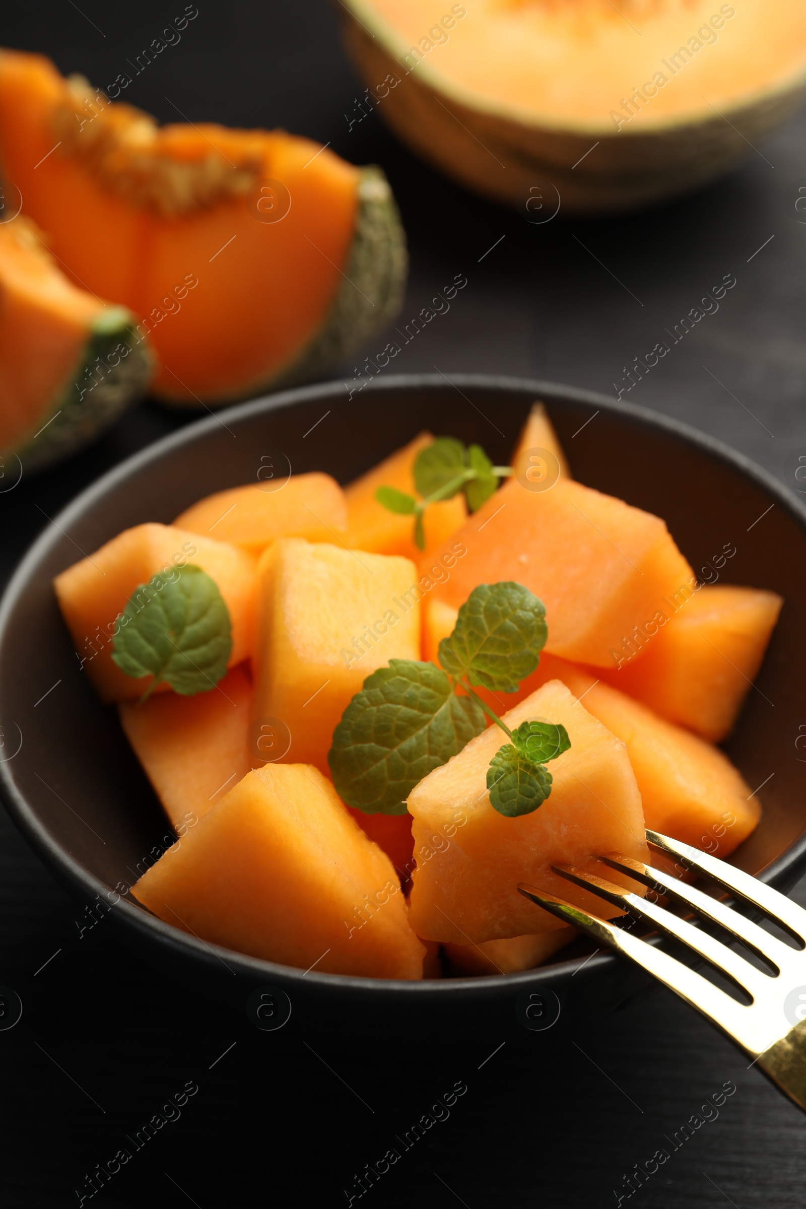 Photo of Pieces of ripe Cantaloupe melon in bowl on table, closeup