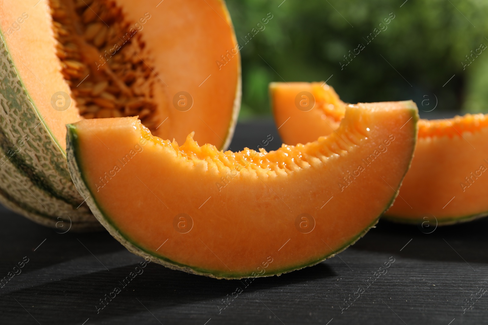 Photo of Fresh ripe Cantaloupe melon on dark wooden table, closeup