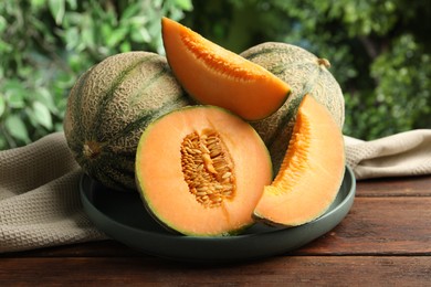 Photo of Fresh ripe Cantaloupe melons on wooden table, closeup