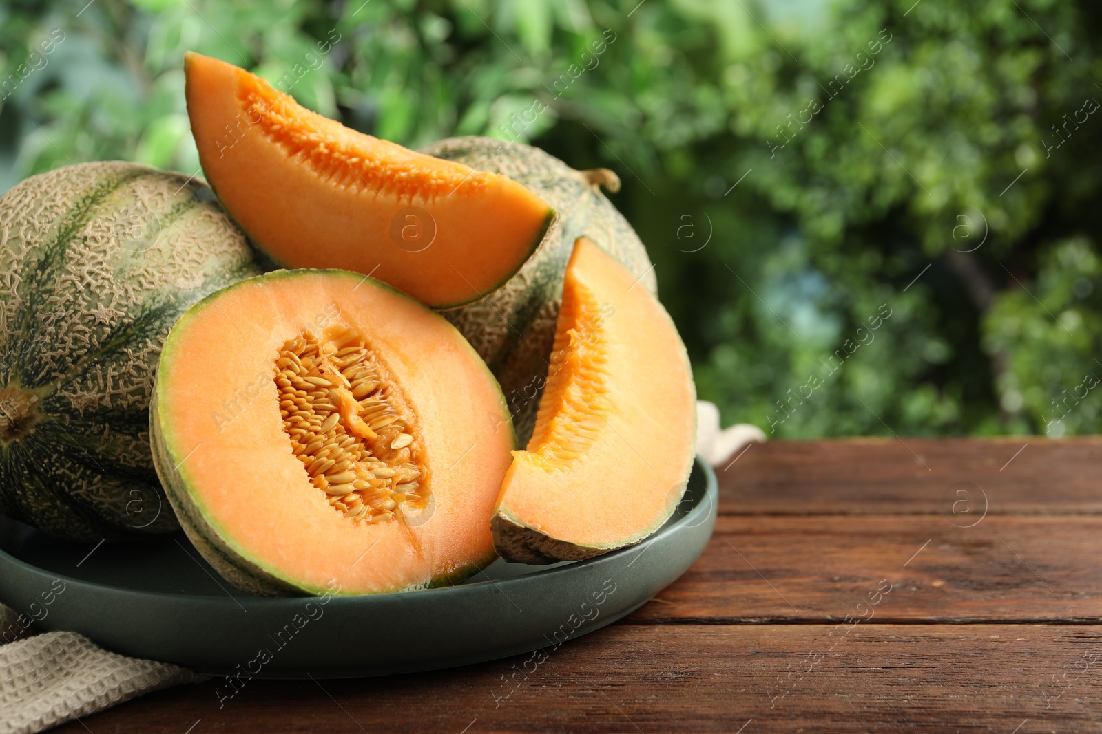 Photo of Fresh ripe Cantaloupe melons on wooden table, closeup. Space for text