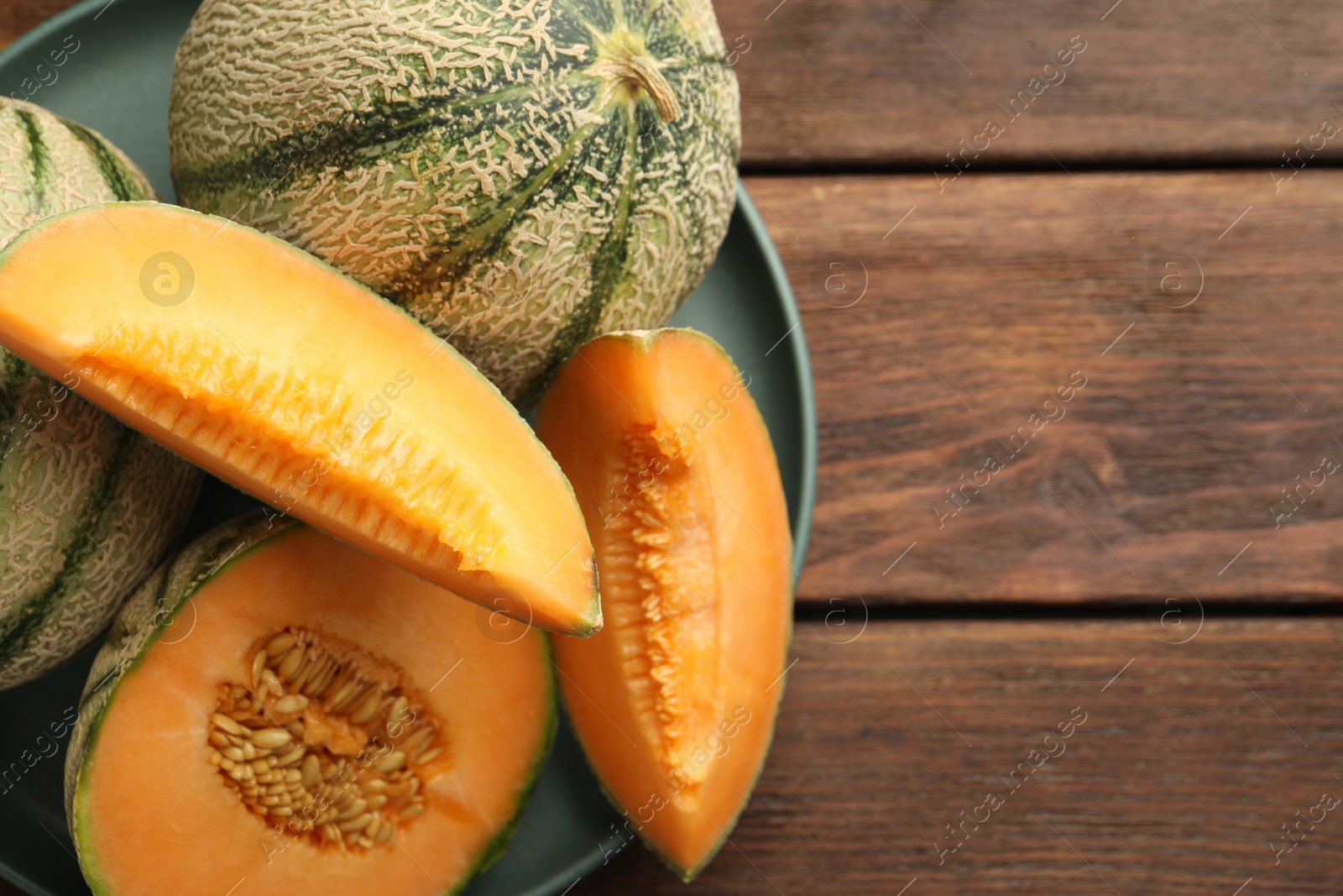 Photo of Fresh ripe Cantaloupe melons on wooden table, top view. Space for text