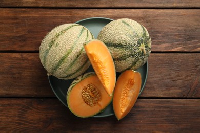 Photo of Fresh ripe Cantaloupe melons on wooden table, top view