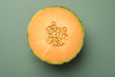 Half of fresh Cantaloupe melon on green table, top view