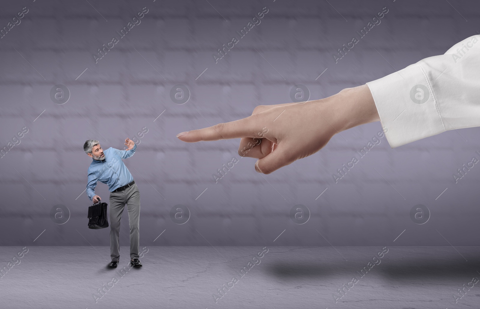 Image of Big hand pointing at scared small businessman on grey background. Authority, abuse concepts