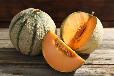 Whole and cut ripe Cantaloupe melons on wooden table