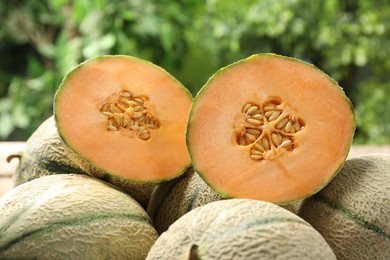 Whole and cut ripe Cantaloupe melons on table outdoors, closeup