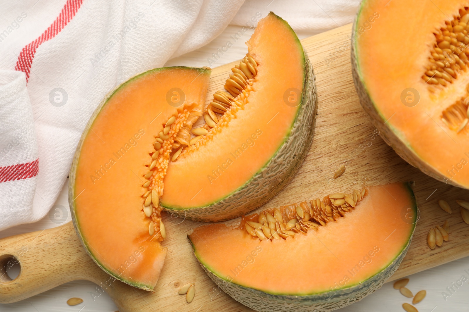 Photo of Cut ripe Cantaloupe melon on white table, flat lay