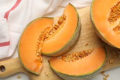 Photo of Cut ripe Cantaloupe melon on white table, flat lay