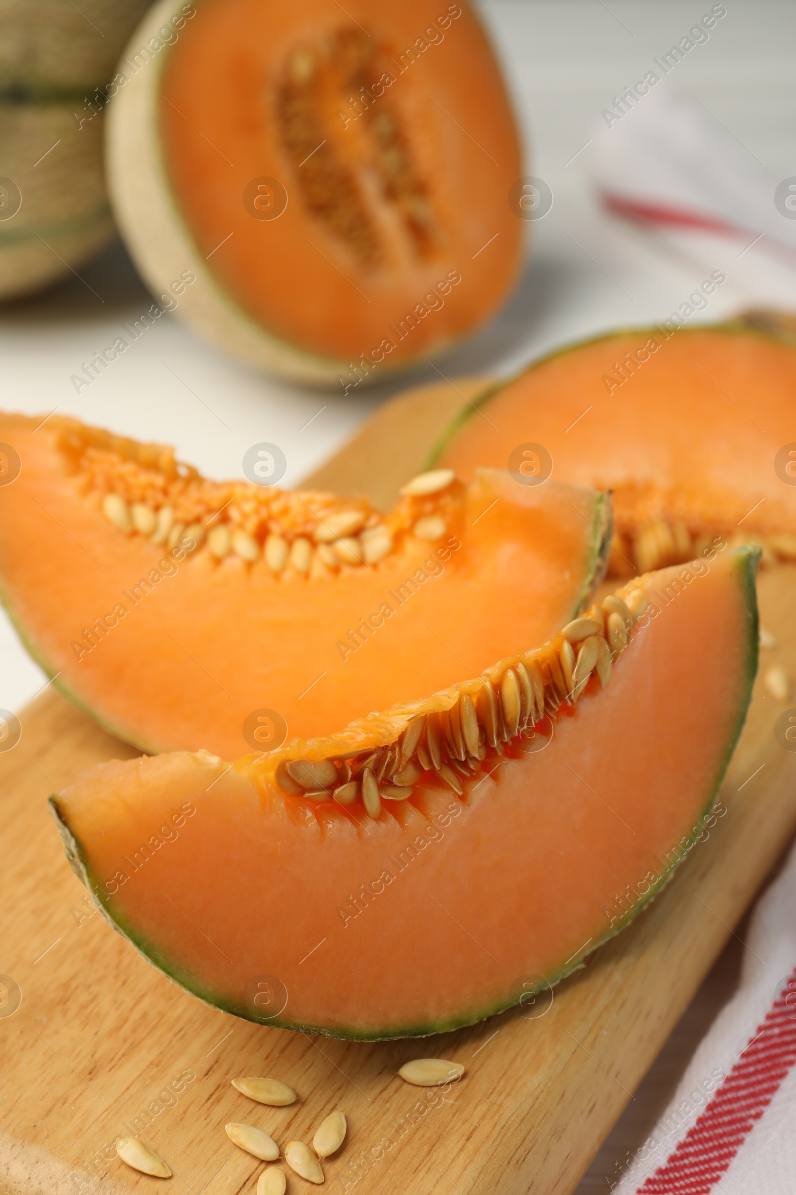 Photo of Cut ripe Cantaloupe melon on white table, closeup