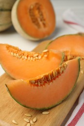 Photo of Cut ripe Cantaloupe melon on white table, closeup