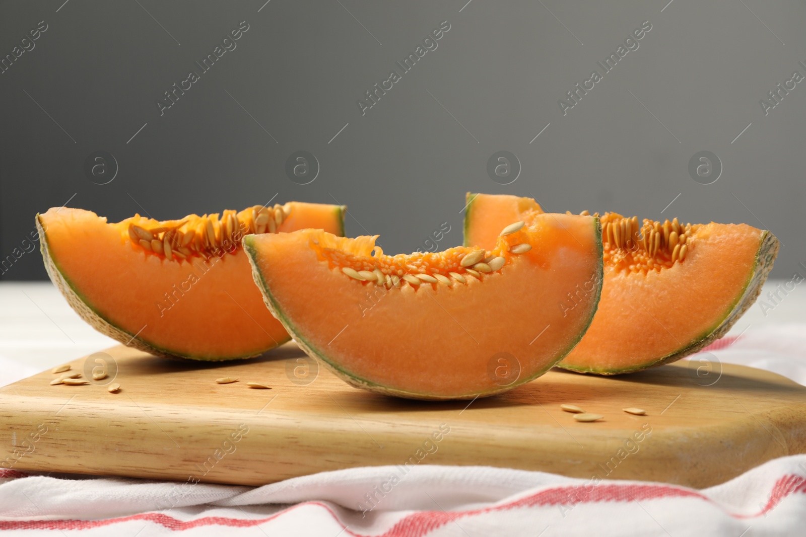 Photo of Cut ripe Cantaloupe melon on white table