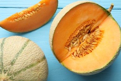 Photo of Cut and whole ripe Cantaloupe melons on light blue wooden table, flat lay