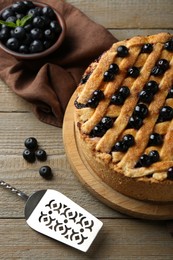 Photo of Homemade blueberry pie, cake server and fresh berries on wooden table