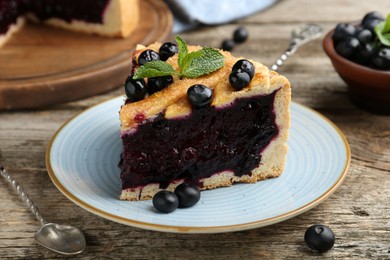 Photo of Slice of homemade blueberry pie on wooden table, closeup