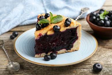 Photo of Slice of homemade blueberry pie on wooden table, closeup