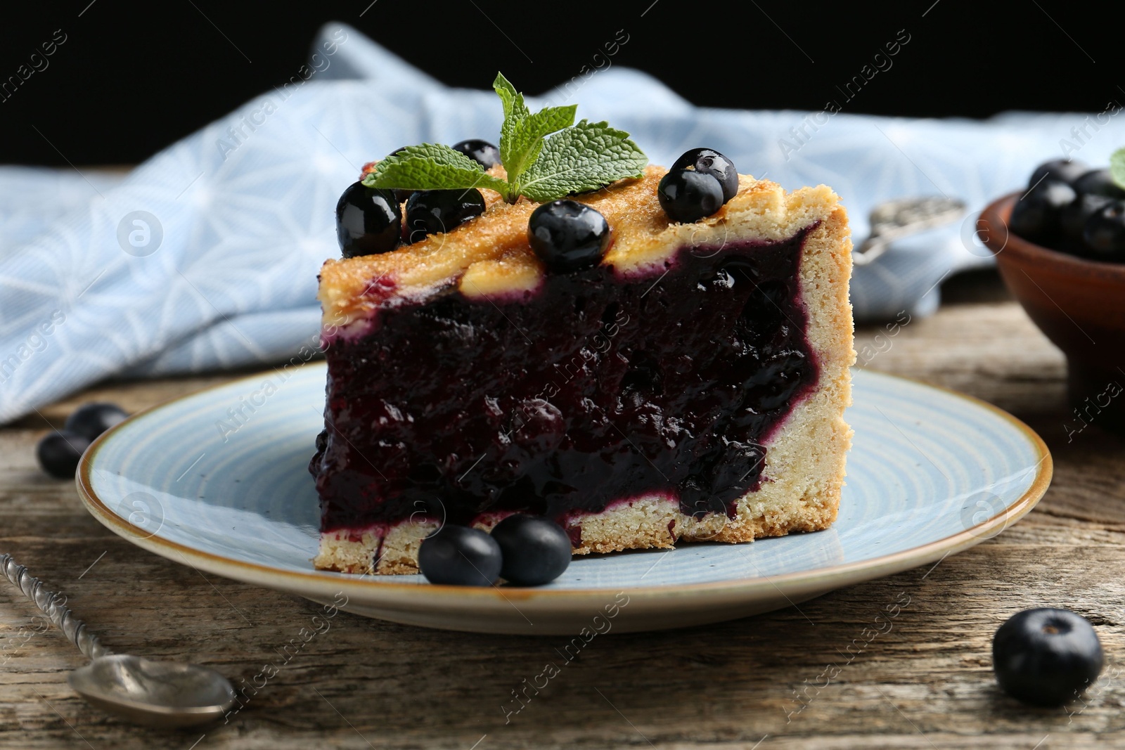 Photo of Slice of homemade blueberry pie on wooden table, closeup