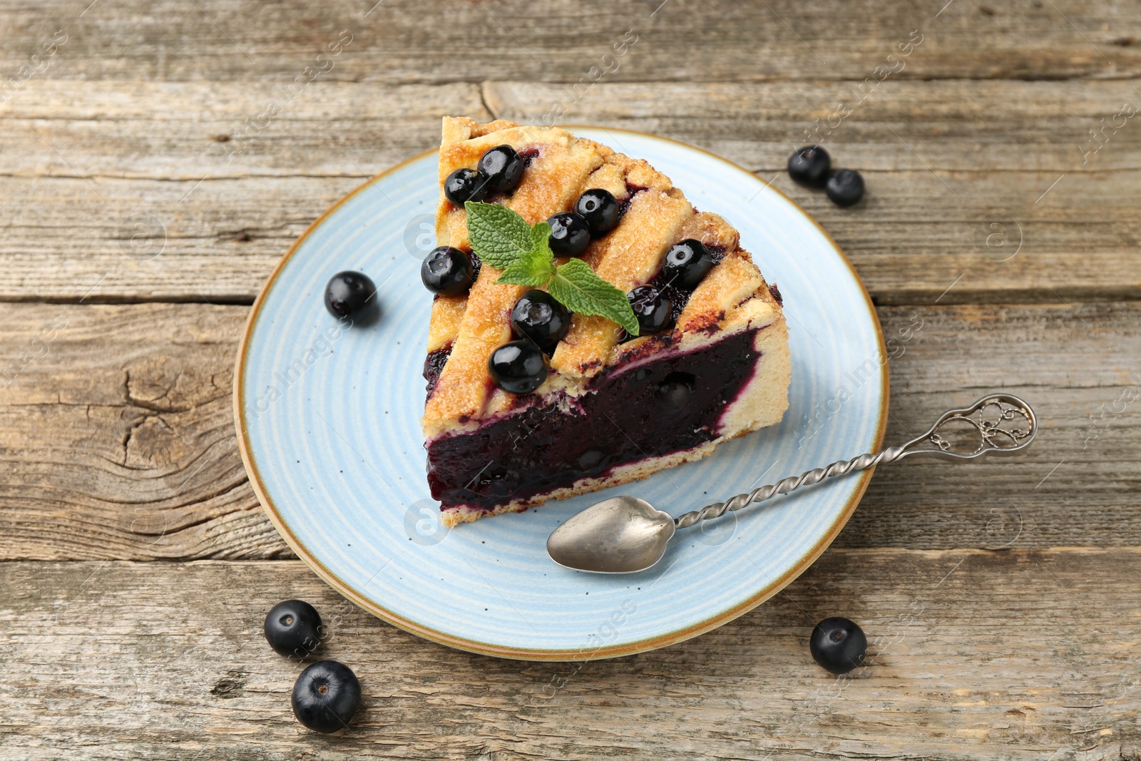 Photo of Slice of homemade blueberry pie on wooden table