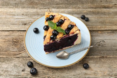 Photo of Slice of homemade blueberry pie on wooden table