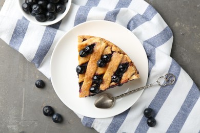 Photo of Slice of delicious homemade blueberry pie served on grey table, flat lay