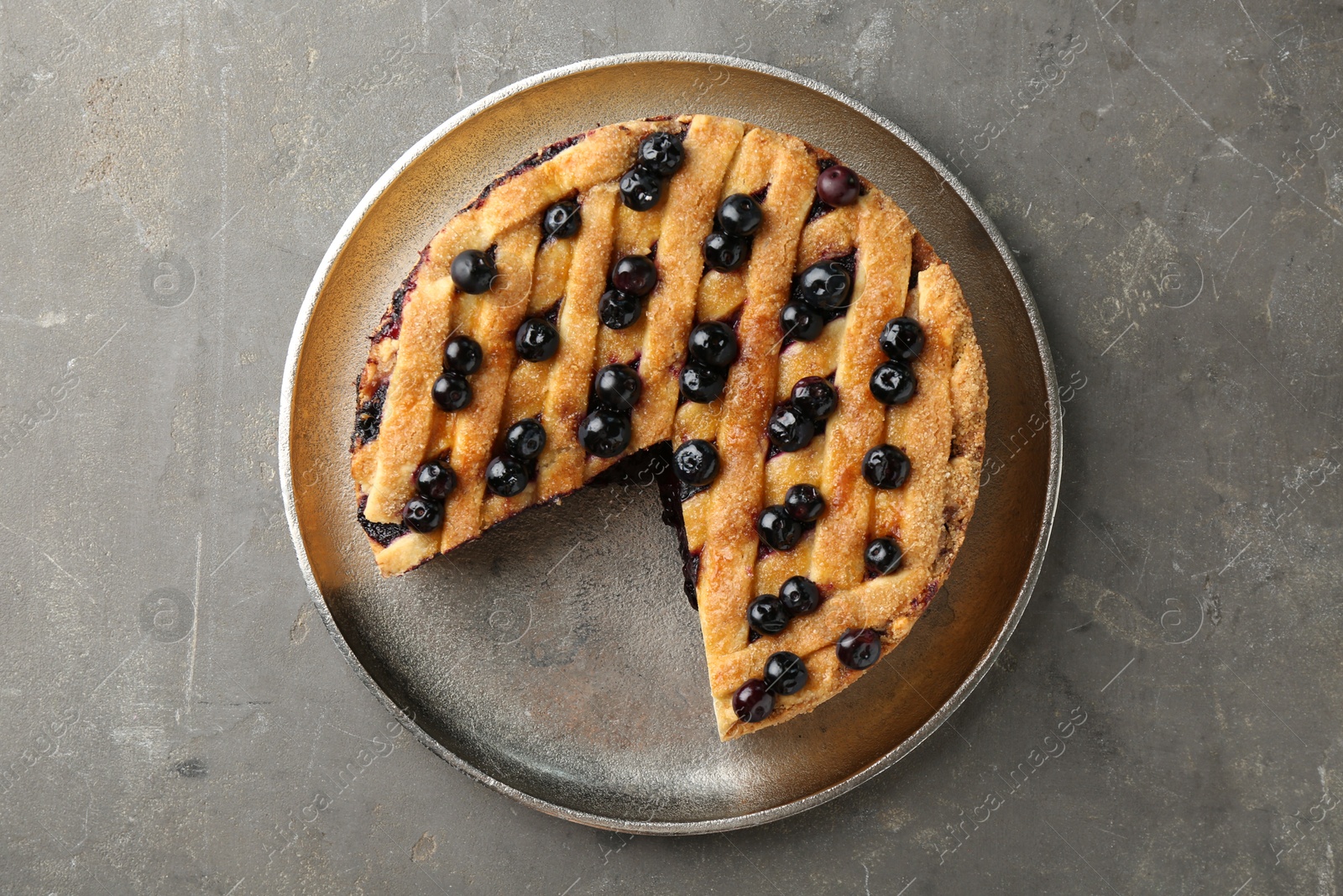 Photo of Cut homemade blueberry pie on grey table, top view