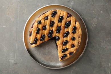 Photo of Cut homemade blueberry pie on grey table, top view