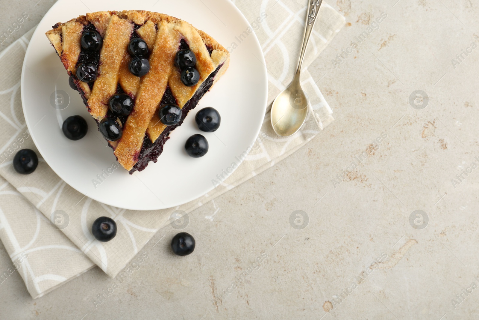 Photo of Slice of delicious homemade blueberry pie served on light table, flat lay. Space for text