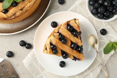 Photo of Slice of delicious homemade blueberry pie served on light table, flat lay