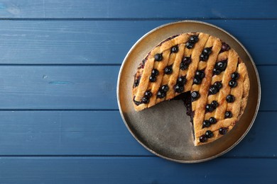 Photo of Cut homemade blueberry pie on blue wooden table, top view. Space for text