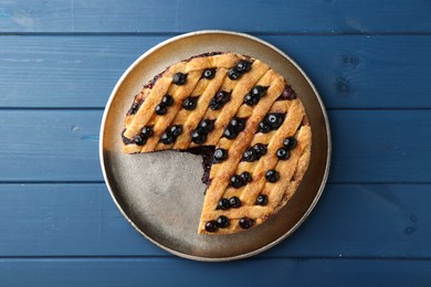 Photo of Cut homemade blueberry pie on blue wooden table, top view