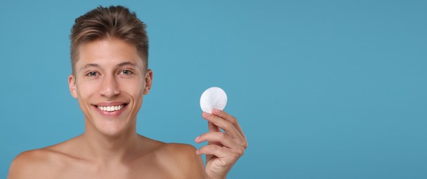 Handsome young man with cotton pad on light blue background. Banner design with space for text