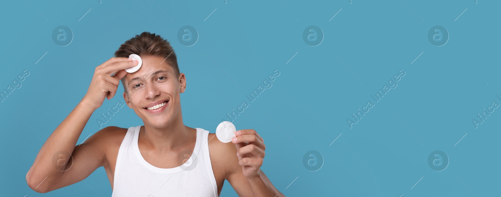 Image of Handsome young man with cotton pads on light blue background. Banner design with space for text