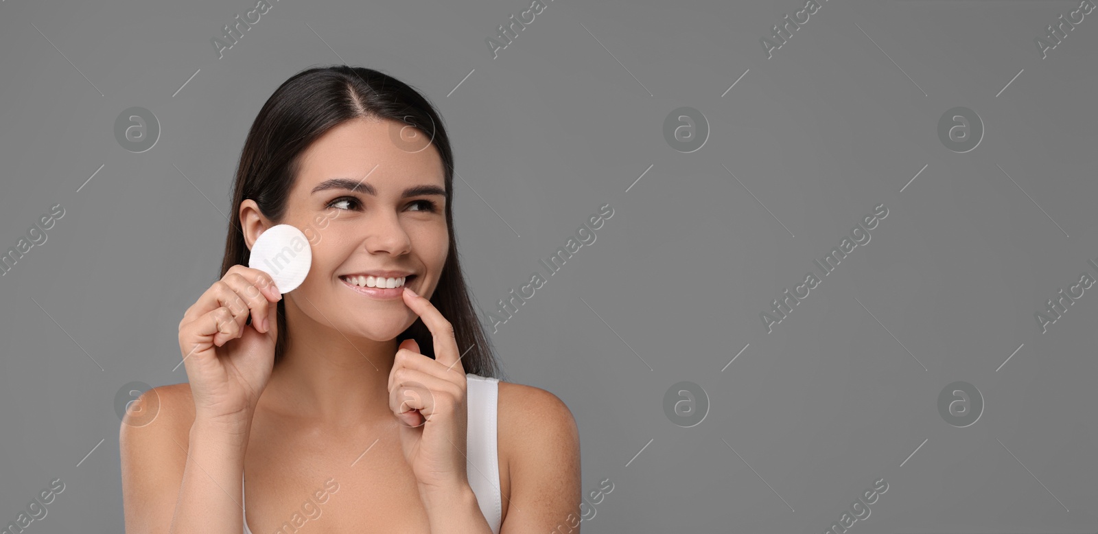 Image of Young woman with cotton pad on grey background. Banner design with space for text