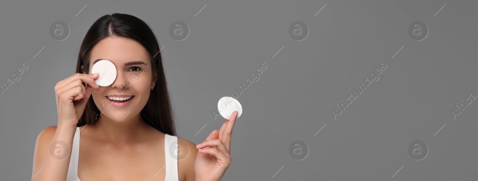 Image of Young woman with cotton pads on grey background. Banner design with space for text