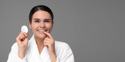 Image of Young woman with cotton pad on grey background. Banner design with space for text