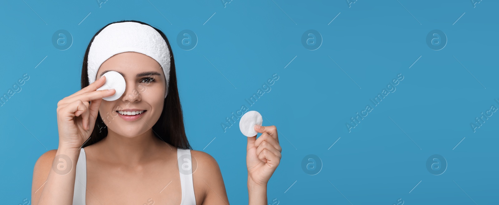 Image of Young woman with cotton pads on light blue background. Banner design with space for text