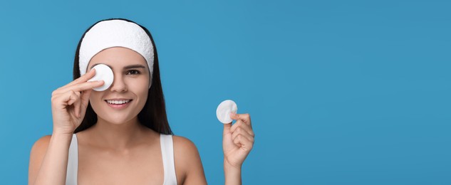 Young woman with cotton pads on light blue background. Banner design with space for text